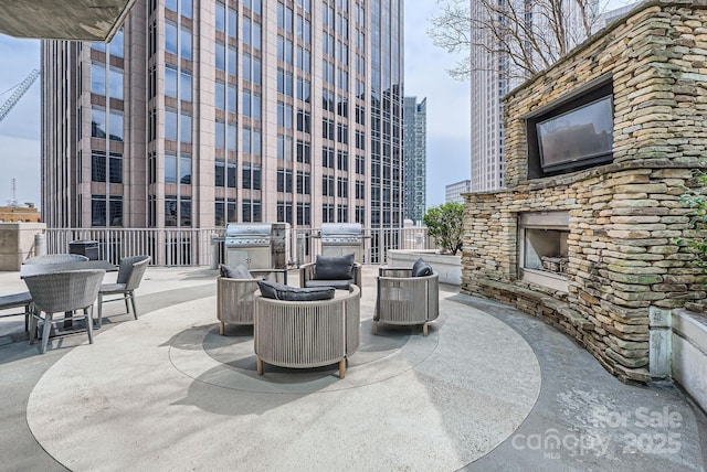 view of patio with area for grilling and an outdoor stone fireplace