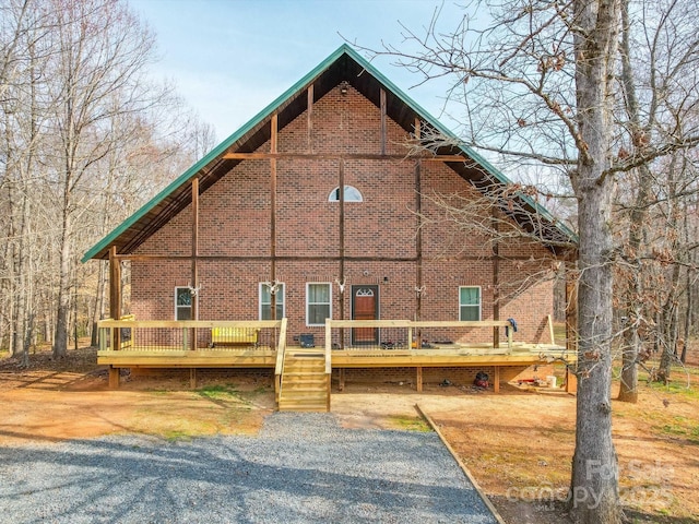 back of house with brick siding and a deck