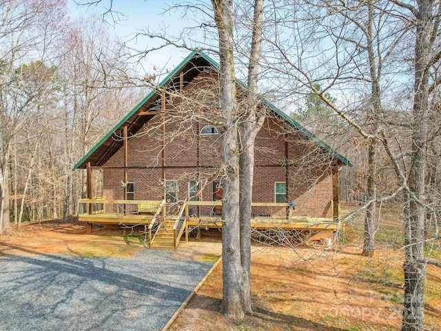 view of front of home with brick siding and a deck