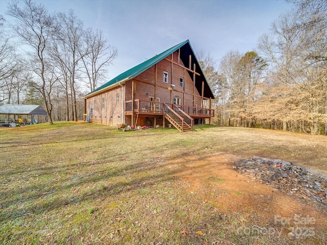 rear view of property featuring a lawn, a deck, and stairs