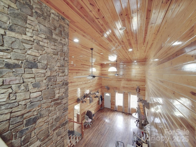 unfurnished living room with wood finished floors, recessed lighting, wood ceiling, and wood walls