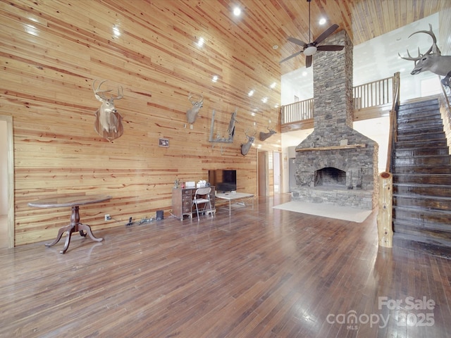 unfurnished living room featuring stairs, wooden ceiling, wood finished floors, and ceiling fan