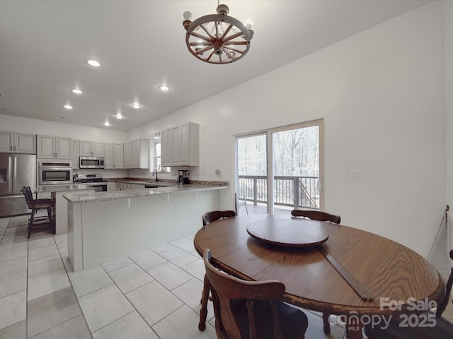 dining space with light tile patterned floors, recessed lighting, a wealth of natural light, and a chandelier