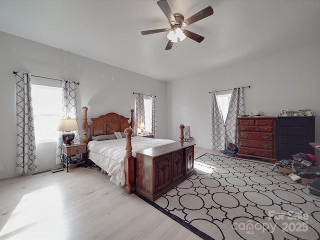 bedroom with multiple windows, a ceiling fan, and light wood finished floors