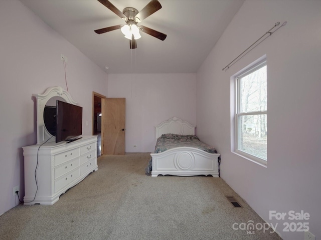 unfurnished bedroom featuring a ceiling fan, light colored carpet, and visible vents