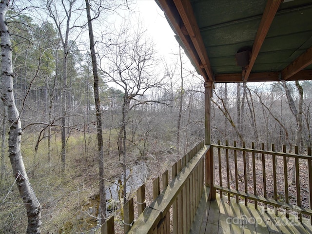 wooden terrace featuring a wooded view