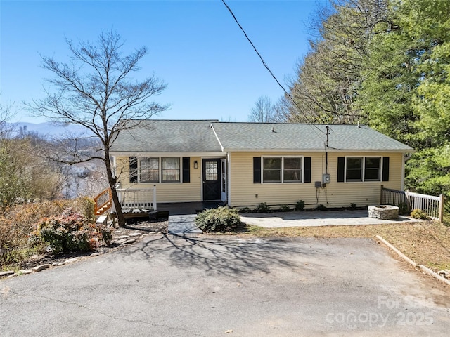 single story home with roof with shingles