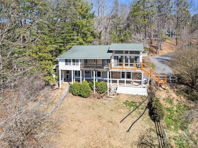 back of property with a patio area, a lawn, stairs, and a sunroom