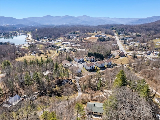 drone / aerial view with a wooded view and a water and mountain view