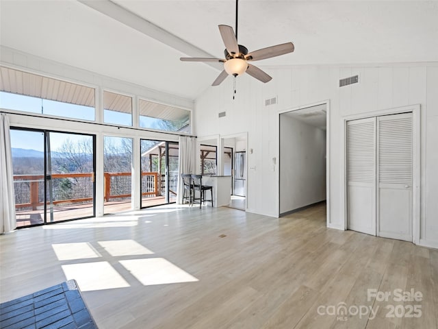 unfurnished living room featuring visible vents, high vaulted ceiling, light wood-type flooring, and a ceiling fan