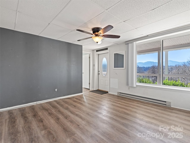 foyer entrance with a paneled ceiling, a baseboard radiator, wood finished floors, and ceiling fan