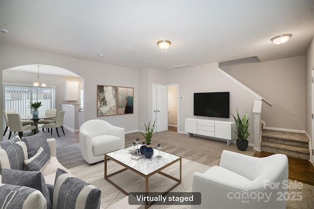 living room with stairway, baseboards, and arched walkways