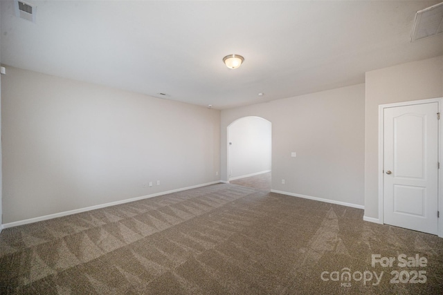 spare room featuring visible vents, arched walkways, baseboards, and carpet flooring