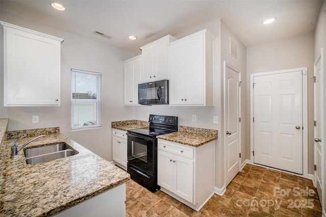 kitchen featuring black appliances, light stone countertops, visible vents, and a sink