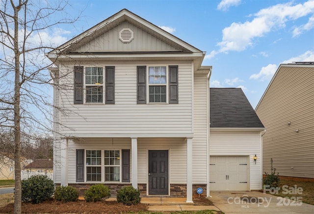 view of front facade with a garage, stone siding, covered porch, and driveway