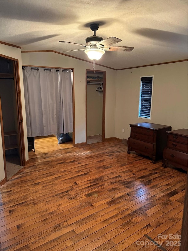 unfurnished bedroom with ornamental molding, a ceiling fan, hardwood / wood-style flooring, a textured ceiling, and lofted ceiling