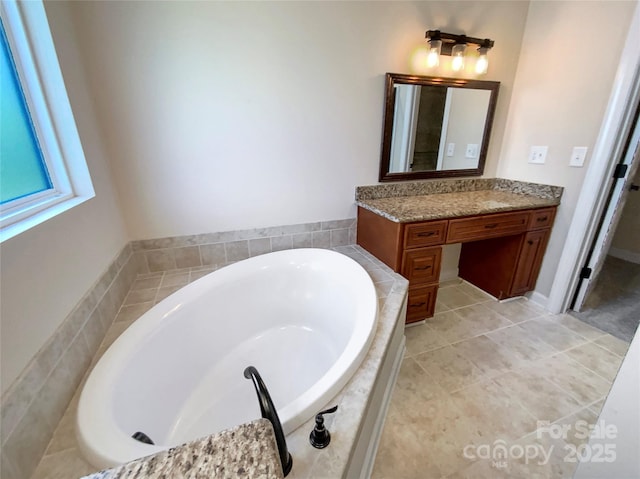 full bath featuring tile patterned flooring, vanity, and a garden tub