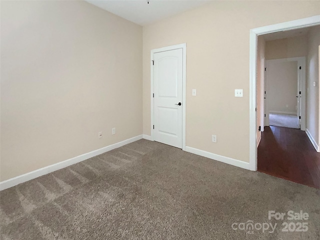 unfurnished bedroom featuring baseboards and dark colored carpet