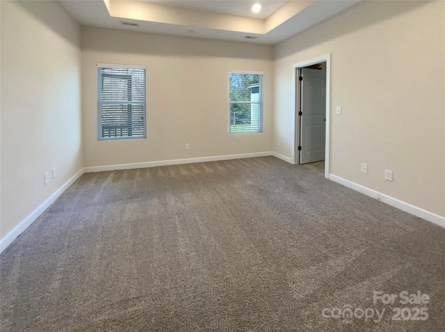 carpeted empty room with recessed lighting, baseboards, and a tray ceiling