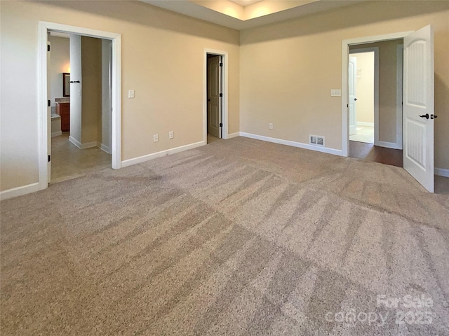 carpeted empty room featuring visible vents and baseboards