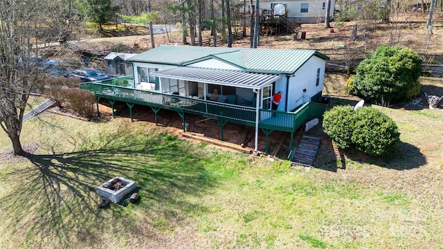 back of house featuring a wooden deck, stairway, a lawn, and metal roof