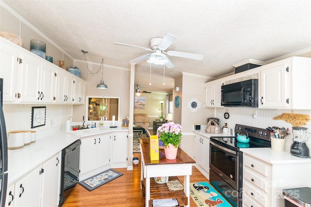 kitchen with a ceiling fan, a sink, black appliances, light countertops, and light wood-style floors