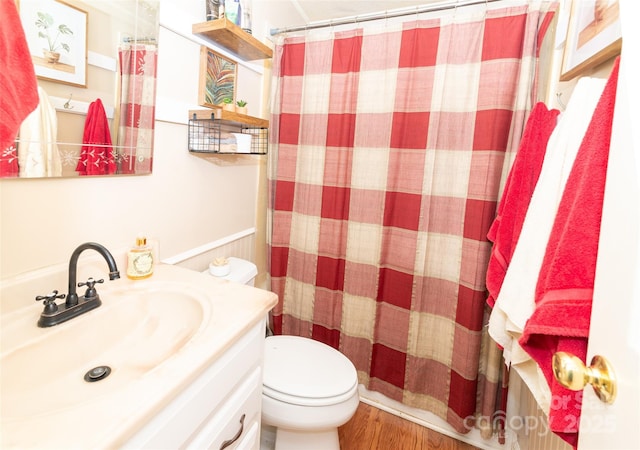 bathroom featuring curtained shower, toilet, vanity, and wood finished floors