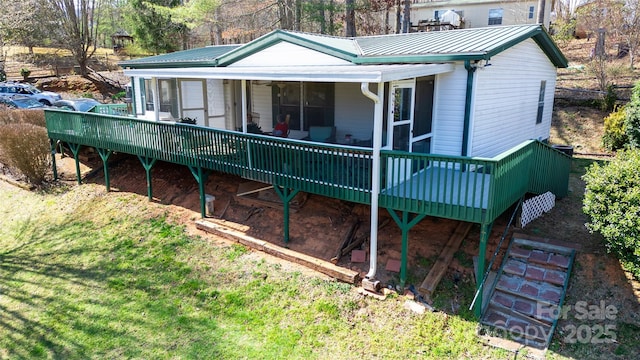 rear view of house with a wooden deck and metal roof