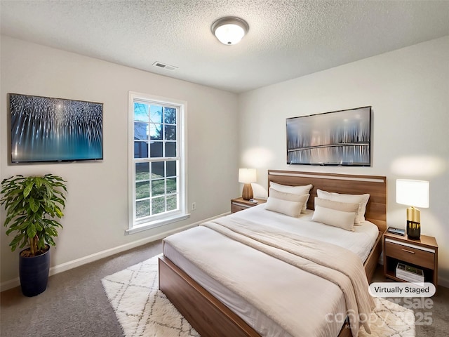 bedroom with visible vents, a textured ceiling, baseboards, and carpet floors