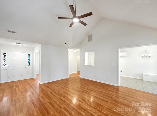 unfurnished living room with light wood finished floors, visible vents, and ceiling fan with notable chandelier