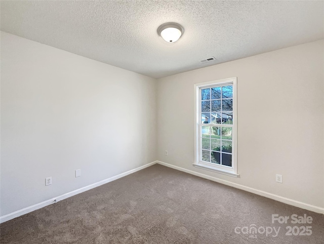 carpeted empty room featuring visible vents, baseboards, and a textured ceiling