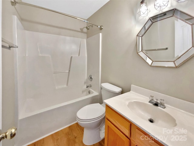 full bath with shower / bathtub combination, toilet, wood finished floors, and vanity