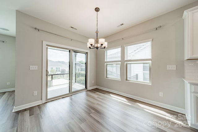 1819 Lotus Ln, Denver, NC 28037 - unfurnished dining area with a chandelier, light wood-style floors, and baseboards