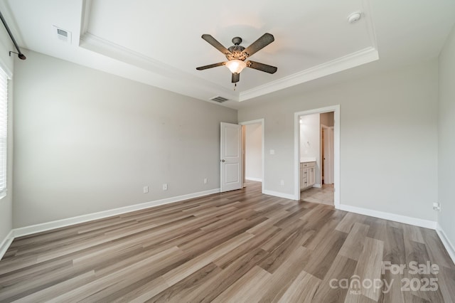 1819 Lotus Ln, Denver, NC 28037 - unfurnished bedroom with a tray ceiling, light wood finished floors, baseboards, a ceiling fan, and connected bathroom