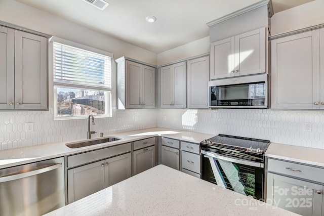 kitchen with a sink, visible vents, appliances with stainless steel finishes, and gray cabinets