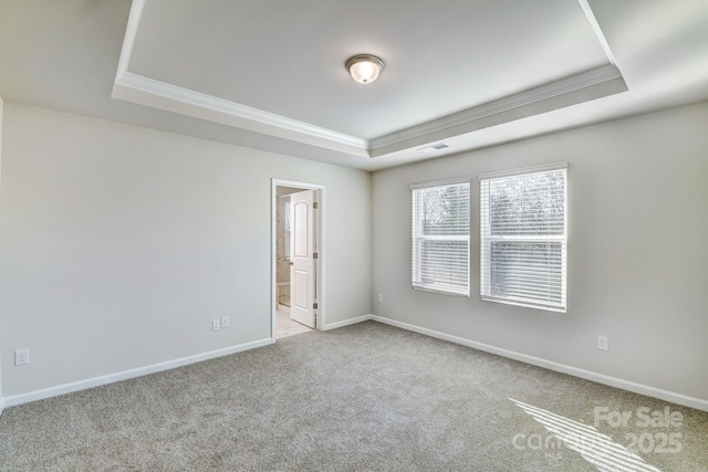 carpeted empty room featuring baseboards, a raised ceiling, visible vents, and ornamental molding