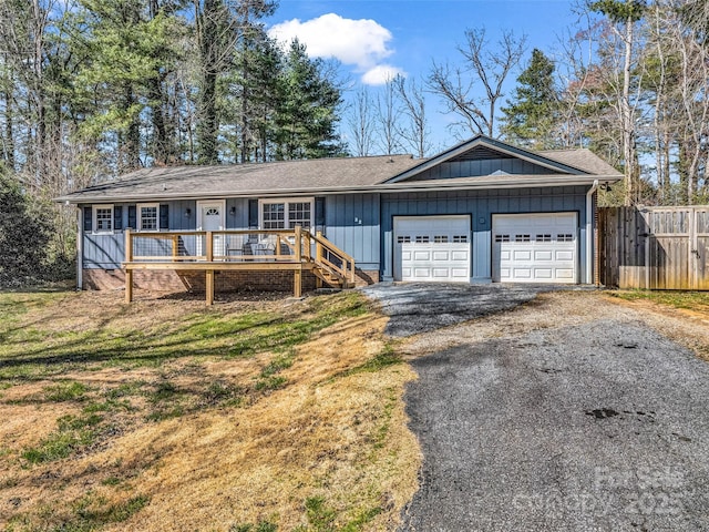 single story home featuring aphalt driveway, a garage, and fence