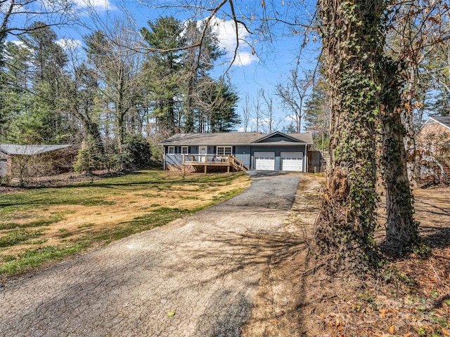 view of front facade featuring a front yard, an attached garage, and driveway