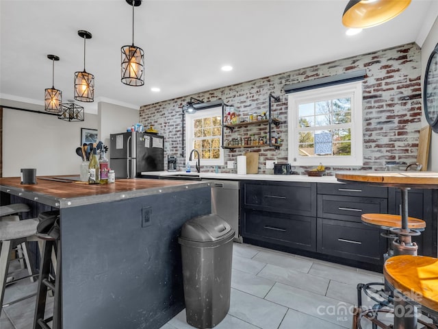 bar featuring indoor wet bar, plenty of natural light, appliances with stainless steel finishes, and light tile patterned flooring