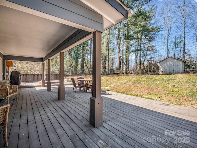 deck with a yard, an outbuilding, a fenced backyard, and a shed