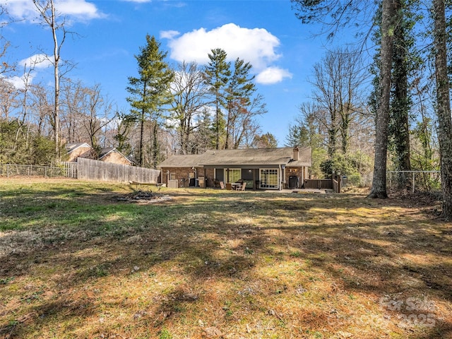 back of property featuring a yard and a fenced backyard