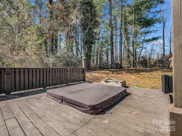 wooden deck featuring a covered hot tub and fence