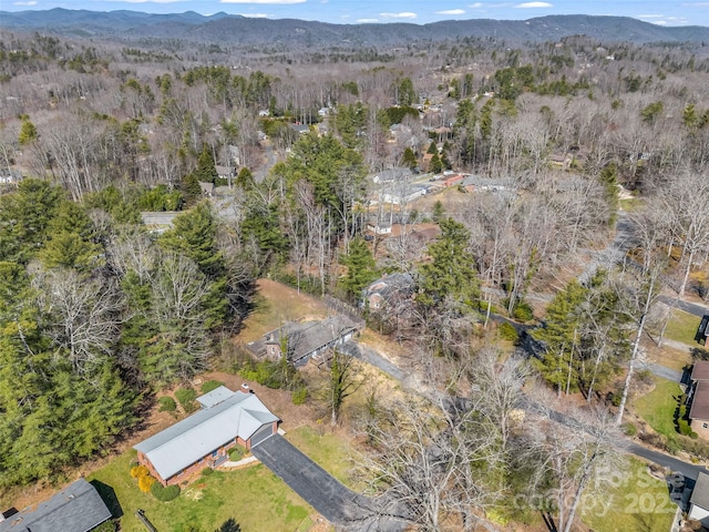 aerial view featuring a wooded view and a mountain view