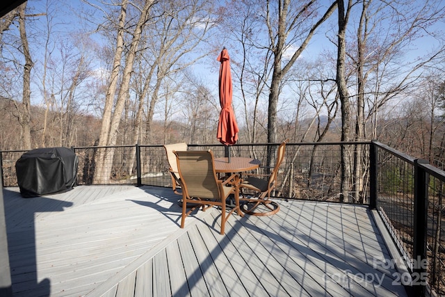 wooden deck featuring outdoor dining space and grilling area