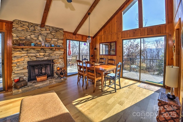 dining room with a wealth of natural light, wooden walls, and wood finished floors