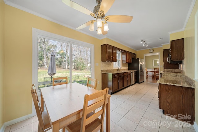 dining room with light tile patterned floors, baseboards, ornamental molding, and a ceiling fan