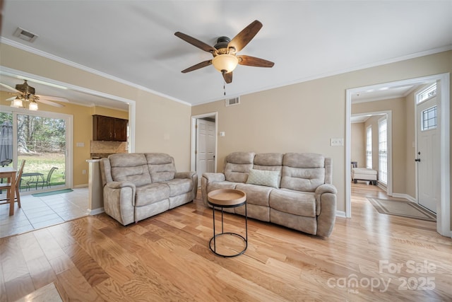 living room featuring visible vents, light wood-style floors, and ceiling fan