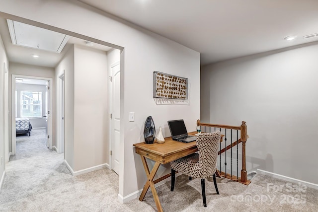 home office with attic access, baseboards, visible vents, and light carpet