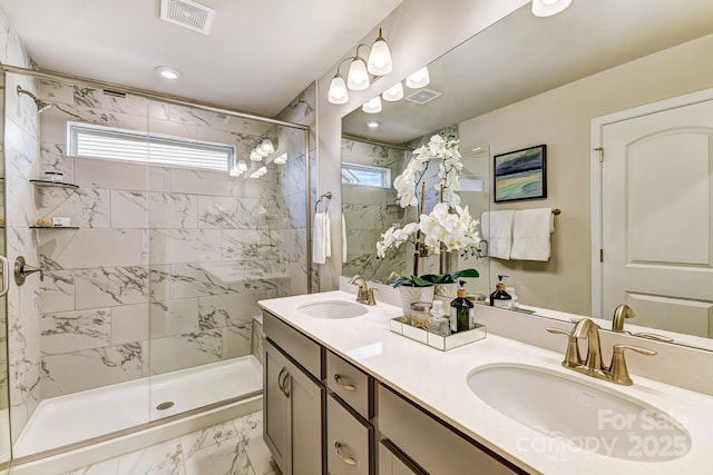 full bath with visible vents, marble finish floor, a shower stall, and a sink