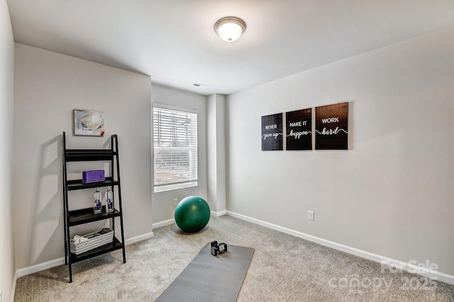 workout room featuring carpet and baseboards